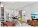 Bright open-plan living area with wood floors, modern decor, a dining area, and stairs to the upper level at 139 Mckim Ave, Indianapolis, IN 46201