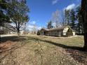 Ranch style home featuring a stone facade, wooden porch, mature trees, and a lush front yard at 1725 E 110Th St, Carmel, IN 46280