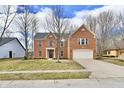 Charming two-story brick home featuring an attached two-car garage and a well-manicured front lawn at 21241 Carlton Ct, Noblesville, IN 46062