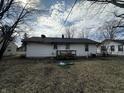 A home's back exterior with a deck area and a grassy yard, framed by bare trees at 308 Mohawk St, Anderson, IN 46012