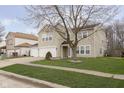 Well-maintained two-story home features green grass, a mature tree and a three-car garage at 3113 Cassara Dr, Indianapolis, IN 46203