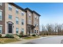 Attractive three-story brick townhome with a landscaped front yard and inviting entryway at 348 Brunswick Way, Zionsville, IN 46077