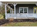 Inviting covered front porch features a seating area, white railing and a yellow front door at 3642 Homestead W Cir, Plainfield, IN 46168