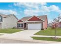 Single-Gathering home with a two-car garage, complemented by a green lawn and blue sky at 389 Longleaf Ln, Greenfield, IN 46140