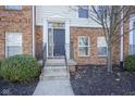 Brick front door with black door, small steps, and neatly trimmed bushes at 427 Windham Pass, Carmel, IN 46032