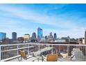 City skyline views from rooftop deck with white railings and wood furniture at 430 N Park Ave # 304, Indianapolis, IN 46202