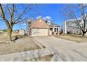 Attractive home with brick facade, an attached garage, a long driveway, and a well-kept front yard at 509 Yorktown Ln, Avon, IN 46123
