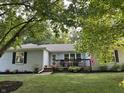 Charming one-story home with a light blue painted brick exterior and a lovely front deck, surrounded by lush green landscaping at 5445 Elderberry Rd, Noblesville, IN 46062