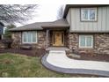 Welcoming front entrance features a beautifully crafted wooden door with sidelights and a manicured garden at 5704 Springhollow Ct, Avon, IN 46123