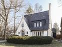 Charming home with a beautiful slate roof, arched doorway, and manicured landscaping creating curb appeal at 6009 N Washington Blvd, Indianapolis, IN 46220