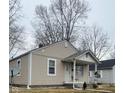 Cozy home with neutral siding, a front porch, simple landscaping and leafless winter trees in background at 620 W Madison St, Alexandria, IN 46001