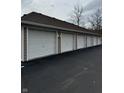 Row of white garages with a blacktop drive, offering ample parking for residents at 6526 Jade Stream Ct # 309, Indianapolis, IN 46237