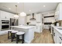 Open kitchen featuring an island with bar stool seating, stainless appliances and wood grain flooring at 7181 Barrett Dr, Brownsburg, IN 46112