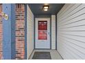 Inviting front entrance with a red-accented door and classic, covered porch at 7463 Pebblebrooke W Dr, Indianapolis, IN 46236