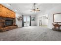 Spacious living room with a brick fireplace, plush carpet, and french doors to the backyard at 7463 Pebblebrooke W Dr, Indianapolis, IN 46236