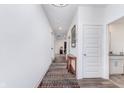 Long hallway with wood-look floors, white walls, and recessed lighting, leading to various rooms in the home at 7658 Hillway Dr, Indianapolis, IN 46113