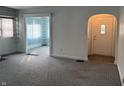 Open-concept living area with new gray carpeting and an arched doorway and multiple entryways at 1023 Union St, Columbus, IN 47201