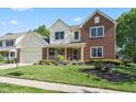 Traditional two-story home featuring a blend of brick and light siding, accentuated by manicured landscaping at 11866 Weathered Edge Dr, Fishers, IN 46037