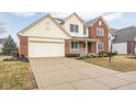 Lovely two-story home showcasing a spacious driveway, brick accents, a covered porch, and an attached two-car garage at 11866 Weathered Edge Dr, Fishers, IN 46037