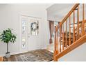 Bright foyer with hardwood floors, staircase, and view into the dining room, creating an inviting entry at 11866 Weathered Edge Dr, Fishers, IN 46037