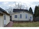 Back of the house featuring yellow siding and view of a detached garage at 1228 E Perry St, Indianapolis, IN 46227