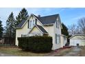 Quaint two-story home with light yellow siding and black roof and shutters at 1228 E Perry St, Indianapolis, IN 46227