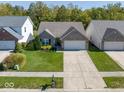 Inviting home with great curb appeal, set within a well-maintained neighborhood, featuring lush lawns and sidewalks at 14963 Mia Dr, Carmel, IN 46033