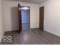 A clean, empty room with gray vinyl flooring, white paneled walls, and a doorway that leads to another room at 1900 E Purdue Rd, Muncie, IN 47303