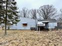 A view of the home's back exterior showing boarded-up windows at 2513 W 10Th St, Muncie, IN 47302