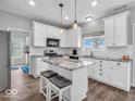 Modern kitchen featuring white cabinets, stainless steel appliances, granite countertops, and a center island with seating at 2808 Twinleaf Dr, Plainfield, IN 46168