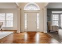 Bright foyer with hardwood floors, white trim, and a view of the front door and sidelight windows at 3880 Heathfield Ct, Zionsville, IN 46077