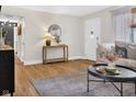 Cozy living room featuring hardwood floors, a round mirror, and neutral decor at 424 Simmons St, Plainfield, IN 46168