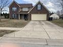 Charming two-story brick home with attached two car garage and a well manicured lawn at 457 Prince Dr, Greenwood, IN 46142