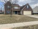 Charming two-story brick home with attached two car garage and a well manicured lawn at 457 Prince Dr, Greenwood, IN 46142