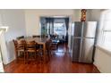 Inviting dining room with wood floors and stainless steel refrigerator next to an open living area at 5068 W 10Th St, Indianapolis, IN 46224