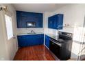 Bright kitchen features stylish blue cabinetry, stainless steel appliances, and a white backsplash at 5068 W 10Th St, Indianapolis, IN 46224