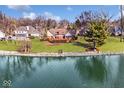 Aerial view of the backyard with lake access, mature trees, and well-maintained lawn at 5519 Fall Creek Rd, Indianapolis, IN 46220
