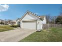 Single-story home with an attached garage, concrete driveway, and manicured lawn at 664 Beaverbrook Dr, Carmel, IN 46032