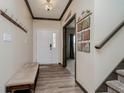 Welcoming entryway featuring wood-look flooring, coat hooks, staircase, and decorative wall art at 6880 W Jennifer Dr, Greenfield, IN 46140
