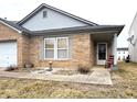 Inviting brick home with a welcoming front porch, sidewalk, and garden accent at 6896 Maywood Cir, Avon, IN 46123