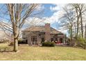 Spacious backyard showcasing a well-maintained lawn, mature trees, and a comfortable outdoor seating area at 7806 Ashtree Dr, Indianapolis, IN 46259