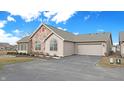 A lovely home exterior featuring a stone accent, attached garage, and well-kept landscaping at 7914 King Post Dr, Indianapolis, IN 46237