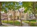 Stunning stone home with mature trees and a charming exterior, showcasing its architectural details and curb appeal at 906 Franklin St, Columbus, IN 47201