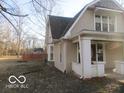 A side view of the charming two-story home highlighting a spacious yard and mature trees at 929 Gilbert Ave, Indianapolis, IN 46227
