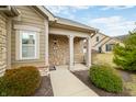 Charming covered front porch with stone columns, landscaping, and a clear walkway at 112 Bridgemor Ln, Mooresville, IN 46158