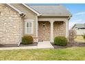 Inviting front porch with stone columns, decorative shrubbery, and a well-maintained lawn at 112 Bridgemor Ln, Mooresville, IN 46158