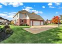 Home featuring a three-car garage and well-maintained landscaping at 11573 Westbury Pl Dr, Carmel, IN 46032