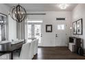 Elegant dining room with modern chandelier, white chairs, and doorway views to the outdoors at 1225 Amberley Way, Westfield, IN 46074