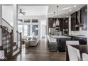 Bright open-concept space with hardwood floors seamlessly integrates the living room and modern kitchen at 1225 Amberley Way, Westfield, IN 46074