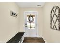 Bright entryway features bench and a decorative coat rack for convenient storage and style at 13 Watson Dr, Trafalgar, IN 46181